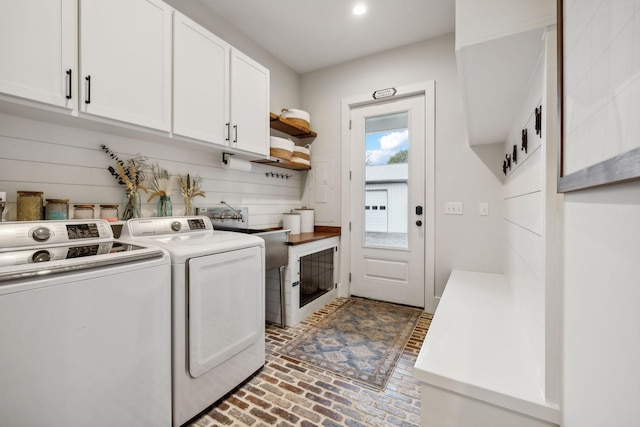 laundry room with washer and dryer, cabinets, and sink