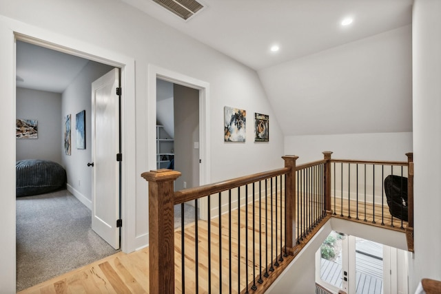 hall with light hardwood / wood-style floors and lofted ceiling