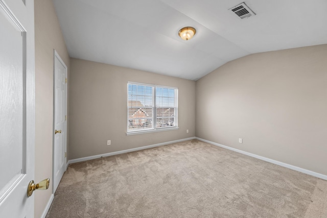 carpeted empty room featuring lofted ceiling