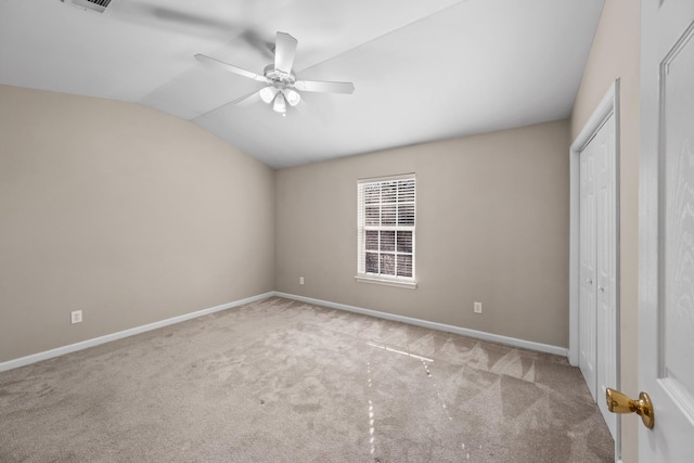 unfurnished bedroom featuring a closet, light carpet, ceiling fan, and vaulted ceiling