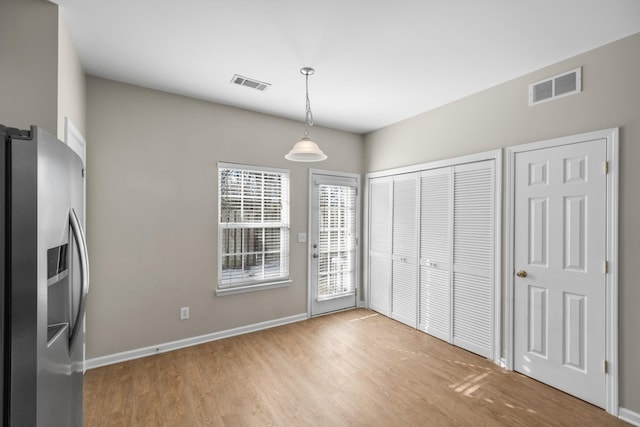 unfurnished dining area with light wood-type flooring