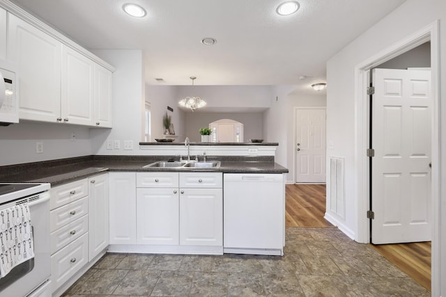 kitchen with white cabinets, white appliances, kitchen peninsula, and sink