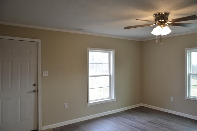 empty room with dark wood-type flooring, ceiling fan, plenty of natural light, and crown molding