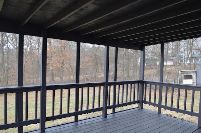 unfurnished sunroom featuring beam ceiling