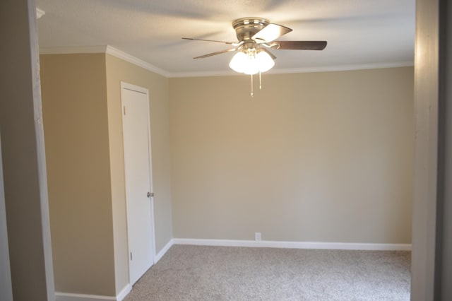 carpeted spare room featuring ceiling fan and ornamental molding