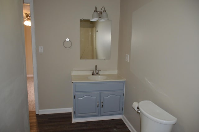 bathroom with hardwood / wood-style floors, ceiling fan, toilet, and vanity