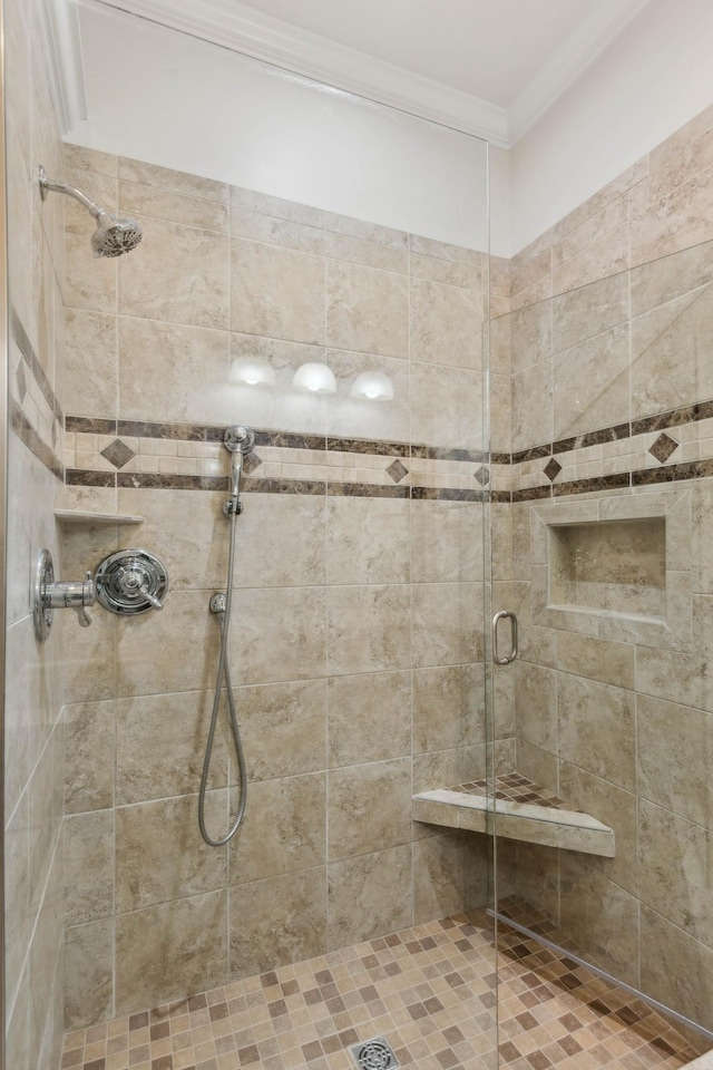 bathroom featuring a shower with door and ornamental molding