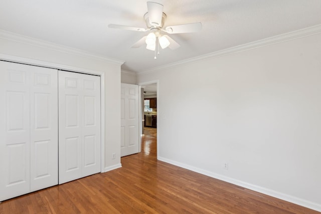 unfurnished bedroom featuring a closet, ceiling fan, crown molding, and wood-type flooring