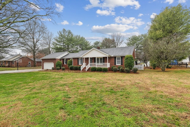 ranch-style home featuring covered porch, a front yard, and a garage