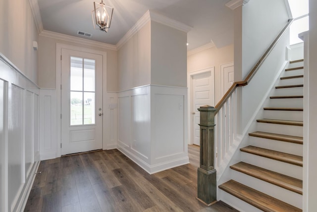 doorway featuring dark wood-type flooring, an inviting chandelier, and ornamental molding