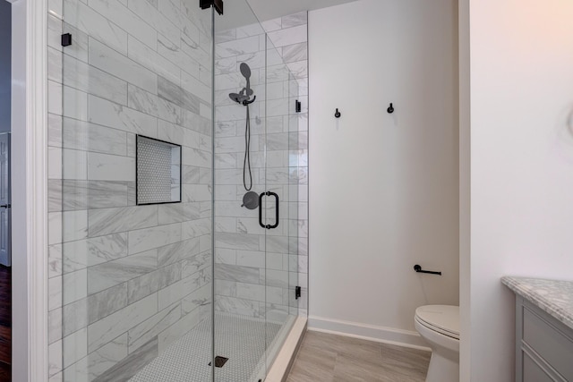 bathroom featuring vanity, toilet, and an enclosed shower