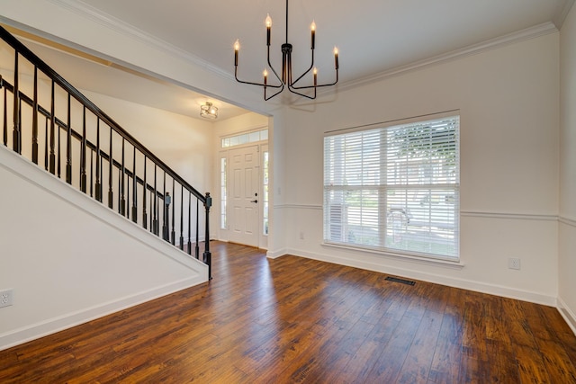 foyer entrance featuring crown molding, dark wood-type flooring, and a notable chandelier