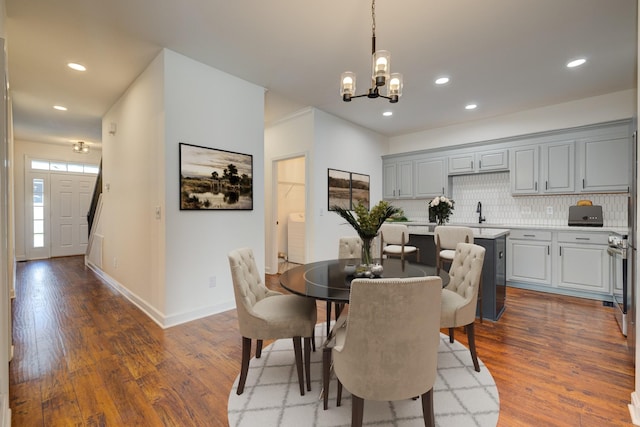 dining room with an inviting chandelier, dark hardwood / wood-style floors, and sink