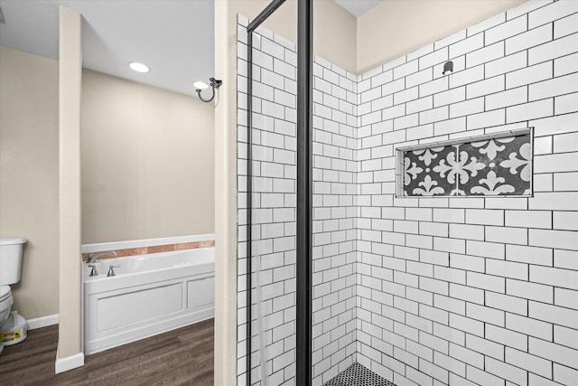 bathroom featuring plus walk in shower, hardwood / wood-style floors, and toilet