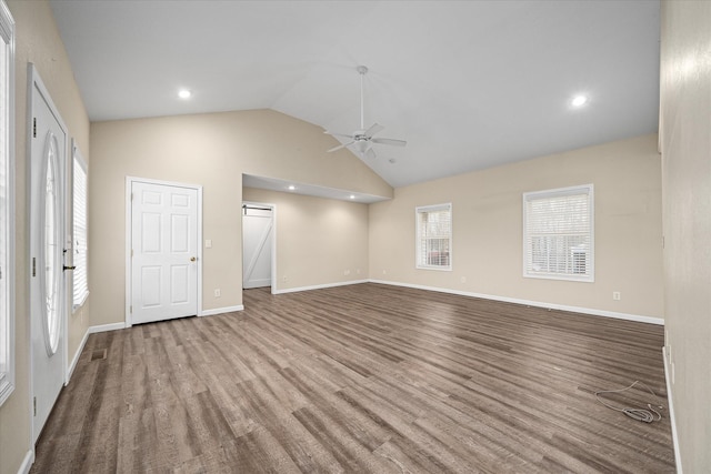 unfurnished living room featuring vaulted ceiling, plenty of natural light, and ceiling fan