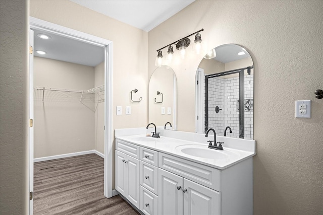 bathroom featuring walk in shower, vanity, and hardwood / wood-style flooring