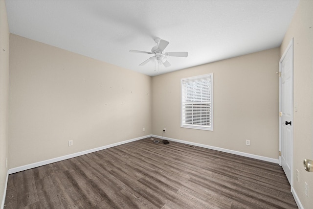 empty room with ceiling fan and dark wood-type flooring