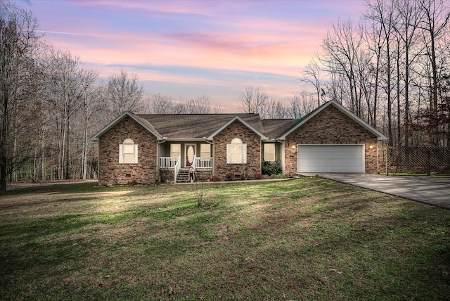 ranch-style home with a porch, a garage, and a lawn