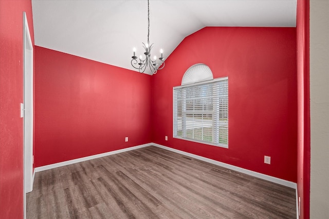 spare room with hardwood / wood-style flooring, a notable chandelier, and vaulted ceiling