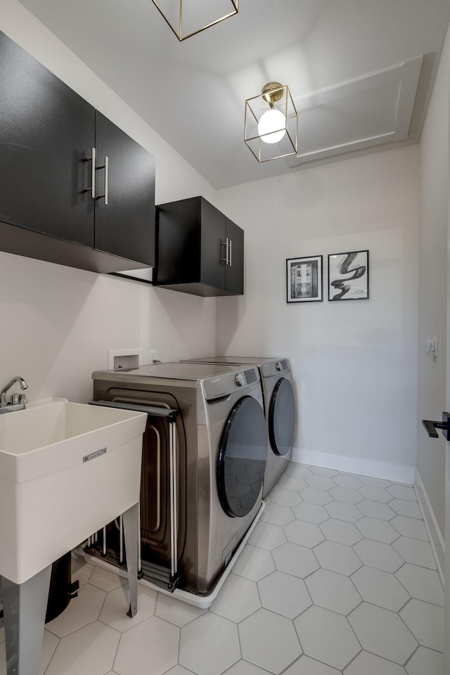 laundry area with cabinets, light tile patterned floors, sink, and washing machine and dryer