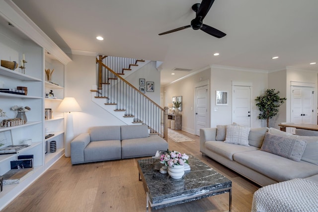 living room with built in shelves, ceiling fan, light hardwood / wood-style flooring, and ornamental molding