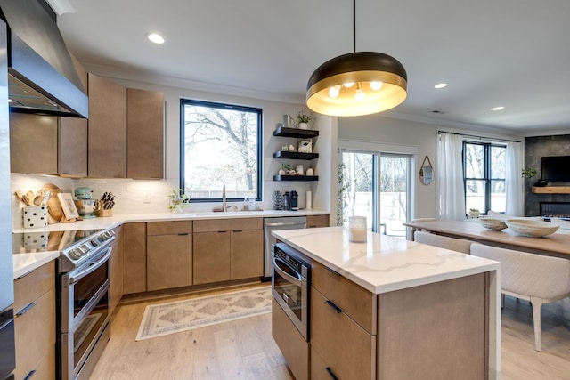 kitchen with appliances with stainless steel finishes, tasteful backsplash, wall chimney exhaust hood, pendant lighting, and a center island