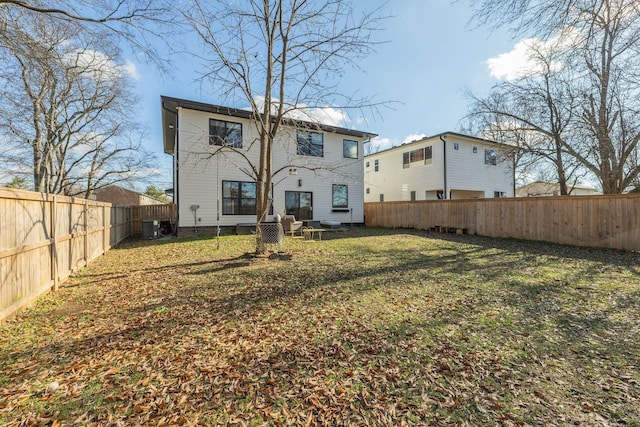 rear view of property with central AC unit and a lawn