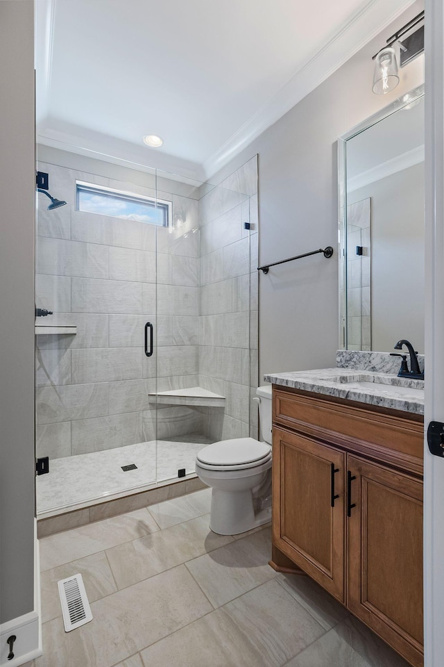 bathroom featuring tile patterned flooring, vanity, ornamental molding, toilet, and walk in shower