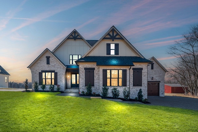 view of front of house featuring a garage and a lawn