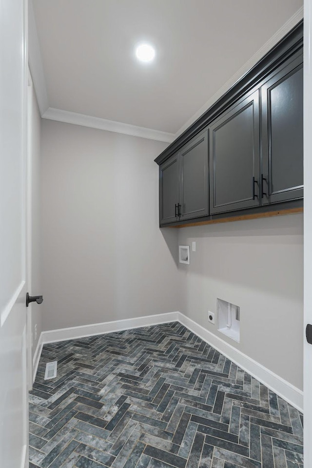 clothes washing area with electric dryer hookup, hookup for a washing machine, crown molding, and cabinets