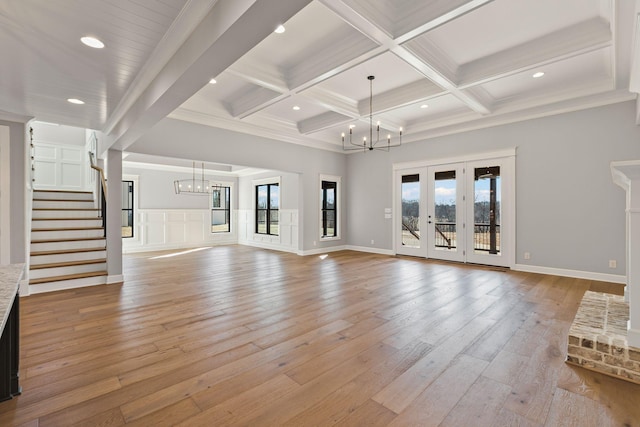 unfurnished living room featuring coffered ceiling, a chandelier, beam ceiling, and light hardwood / wood-style flooring