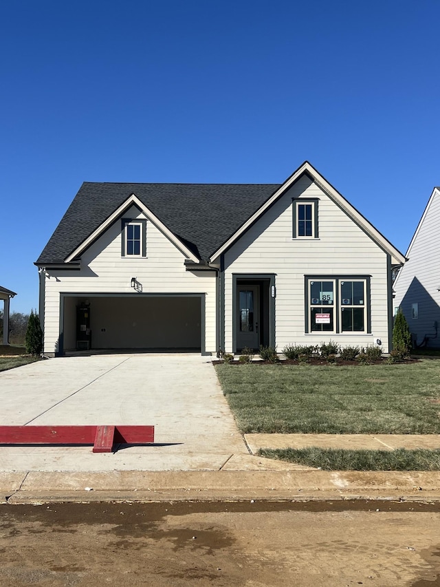 view of front of home with a front yard and a garage