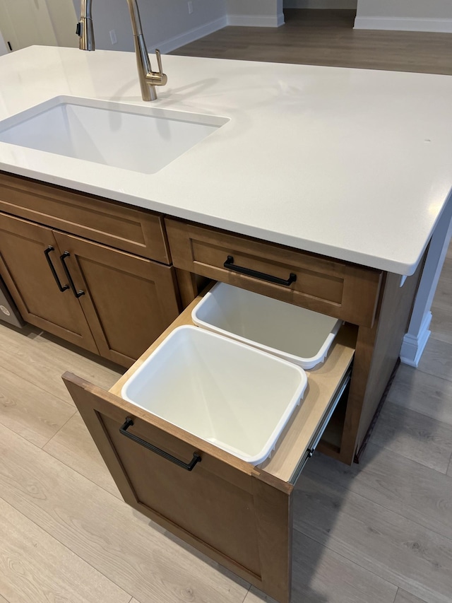 kitchen featuring light hardwood / wood-style floors, a kitchen island with sink, and sink