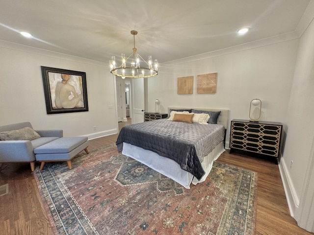 bedroom with wood-type flooring, crown molding, and an inviting chandelier