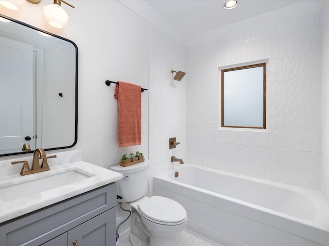 full bathroom featuring tiled shower / bath, vanity, and toilet