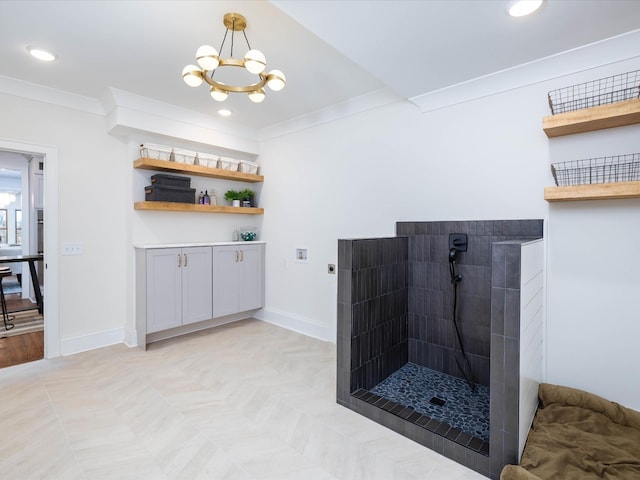 bathroom featuring tiled shower, an inviting chandelier, and crown molding