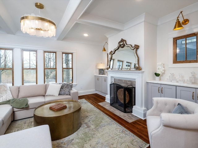 living room with ornamental molding, beamed ceiling, dark wood-type flooring, and a notable chandelier