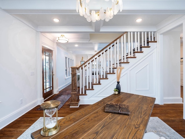 foyer featuring beam ceiling, crown molding, dark wood-type flooring, and a notable chandelier