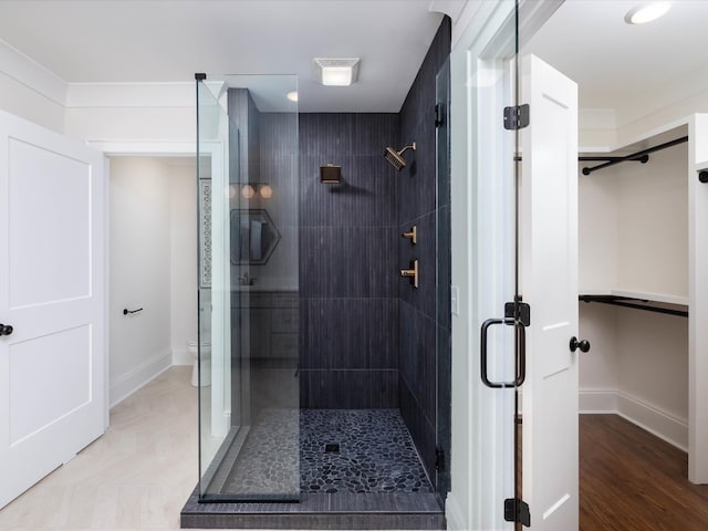 bathroom featuring hardwood / wood-style flooring, an enclosed shower, and toilet