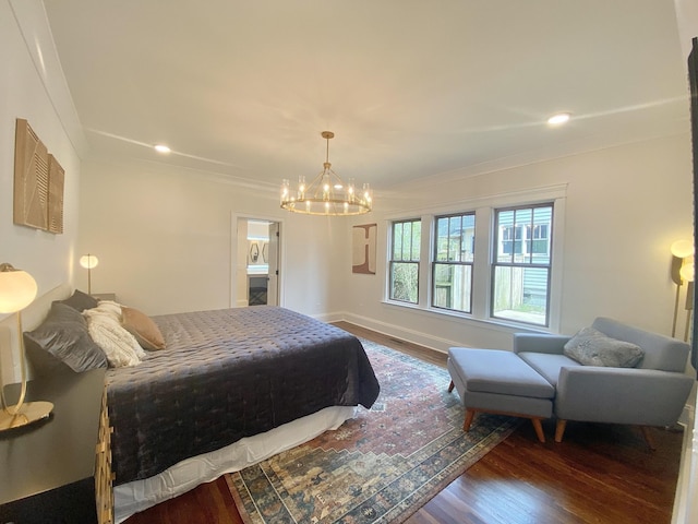 bedroom with a notable chandelier, dark hardwood / wood-style floors, and crown molding