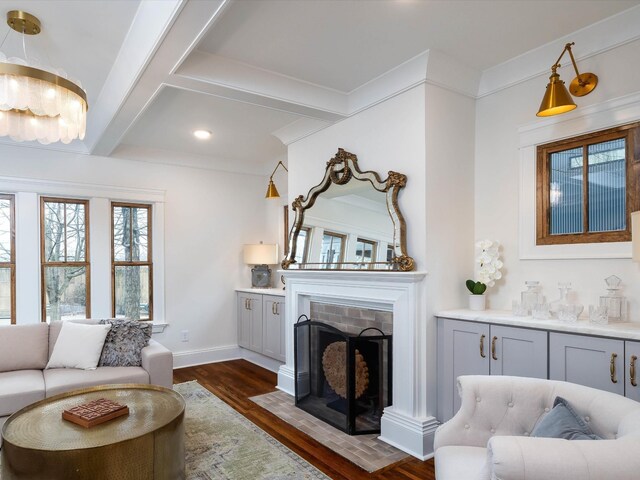 living room with beam ceiling, ornamental molding, and dark wood-type flooring