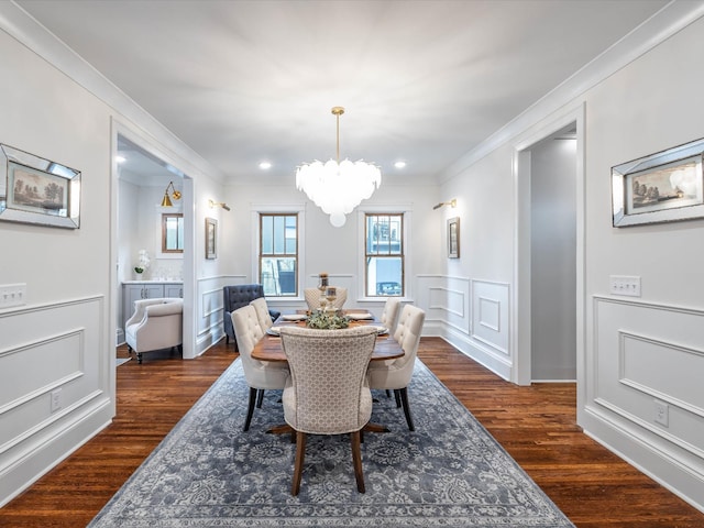 dining space featuring dark hardwood / wood-style flooring, ornamental molding, and a notable chandelier