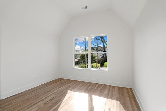 additional living space featuring light hardwood / wood-style floors and lofted ceiling