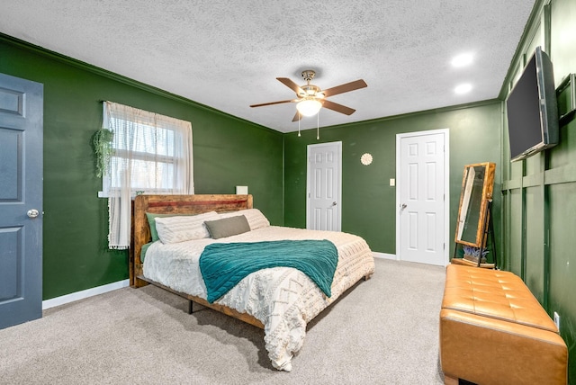 carpeted bedroom featuring a textured ceiling, ceiling fan, and crown molding