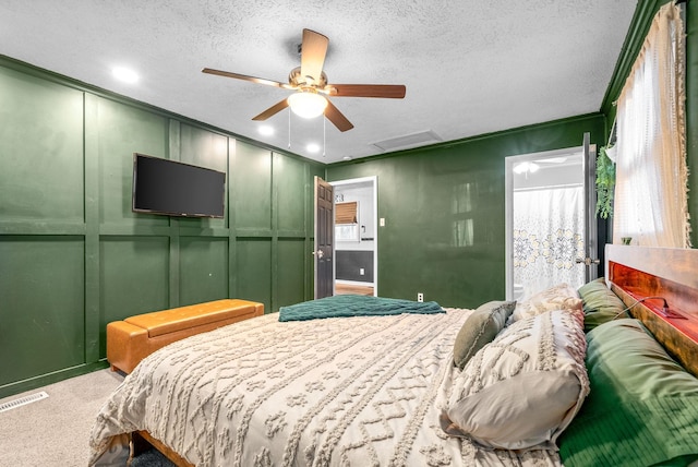 carpeted bedroom with ceiling fan and a textured ceiling