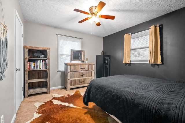 carpeted bedroom with ceiling fan and a textured ceiling