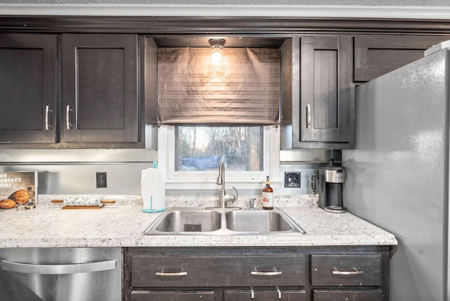 kitchen featuring light stone countertops, dark brown cabinetry, stainless steel appliances, and sink