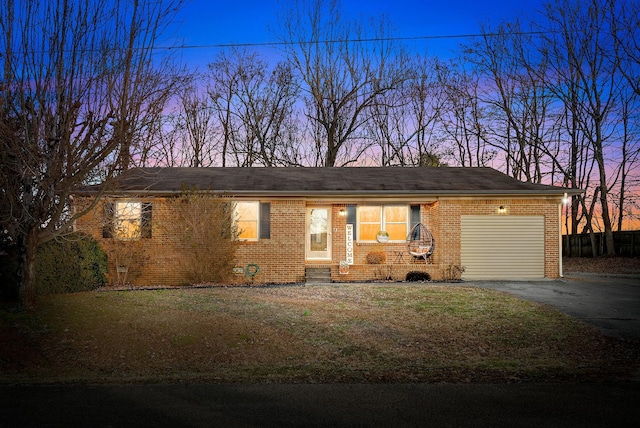 single story home featuring a garage and a yard