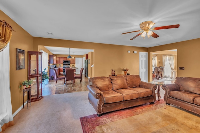 living room featuring ceiling fan and a healthy amount of sunlight