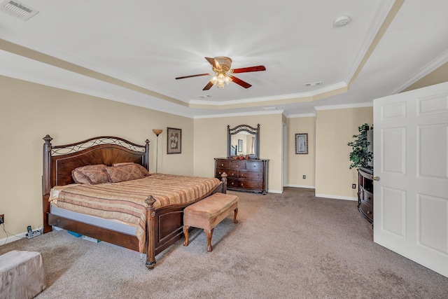 carpeted bedroom featuring ceiling fan, ornamental molding, and a tray ceiling